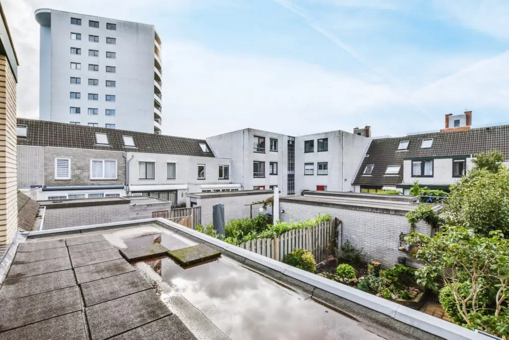 Flat roof of the building and views of other buildings and trees