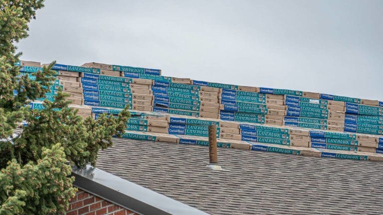 Residential roof with stacks of shingles on top to be used for residential roofing