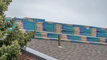Commercial building roof with stacks of shingles on top Residential roof with stacks of shingles on top to be used for residential roofing