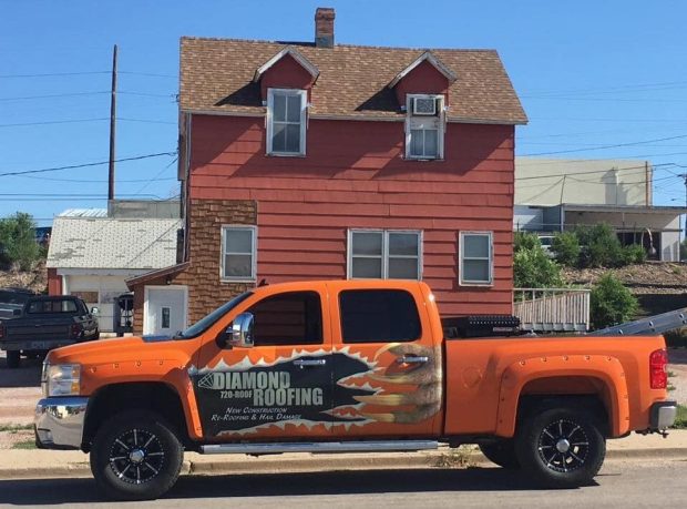 Diamond Roofing Truck in front of home with red siding
